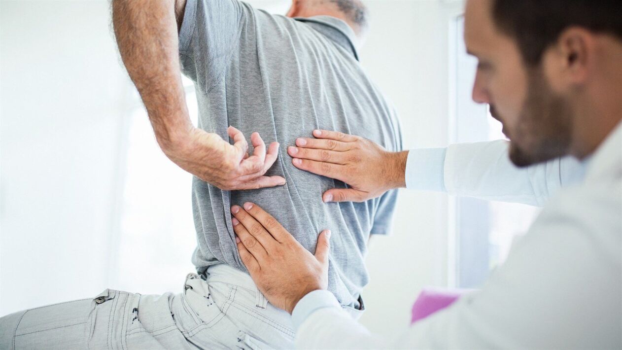 médico examina la espalda con osteocondrosis lumbar
